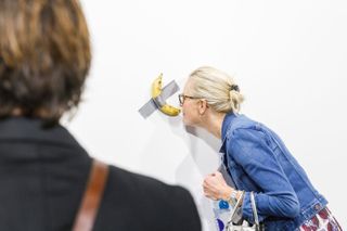An Art Basel visitor gets a closer look at Maurizio Cattelan's Comedian, which was subsequently eaten by Georgian performance artist David Datuna. © Art Basel 