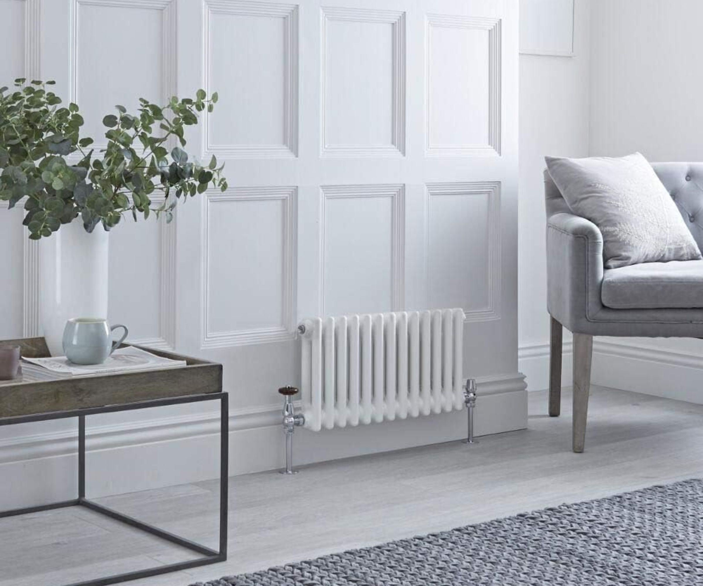 Milano Windsor White Cast Iron Style Horizontal Double Column Radiator in a lifestyle shot next to sofa