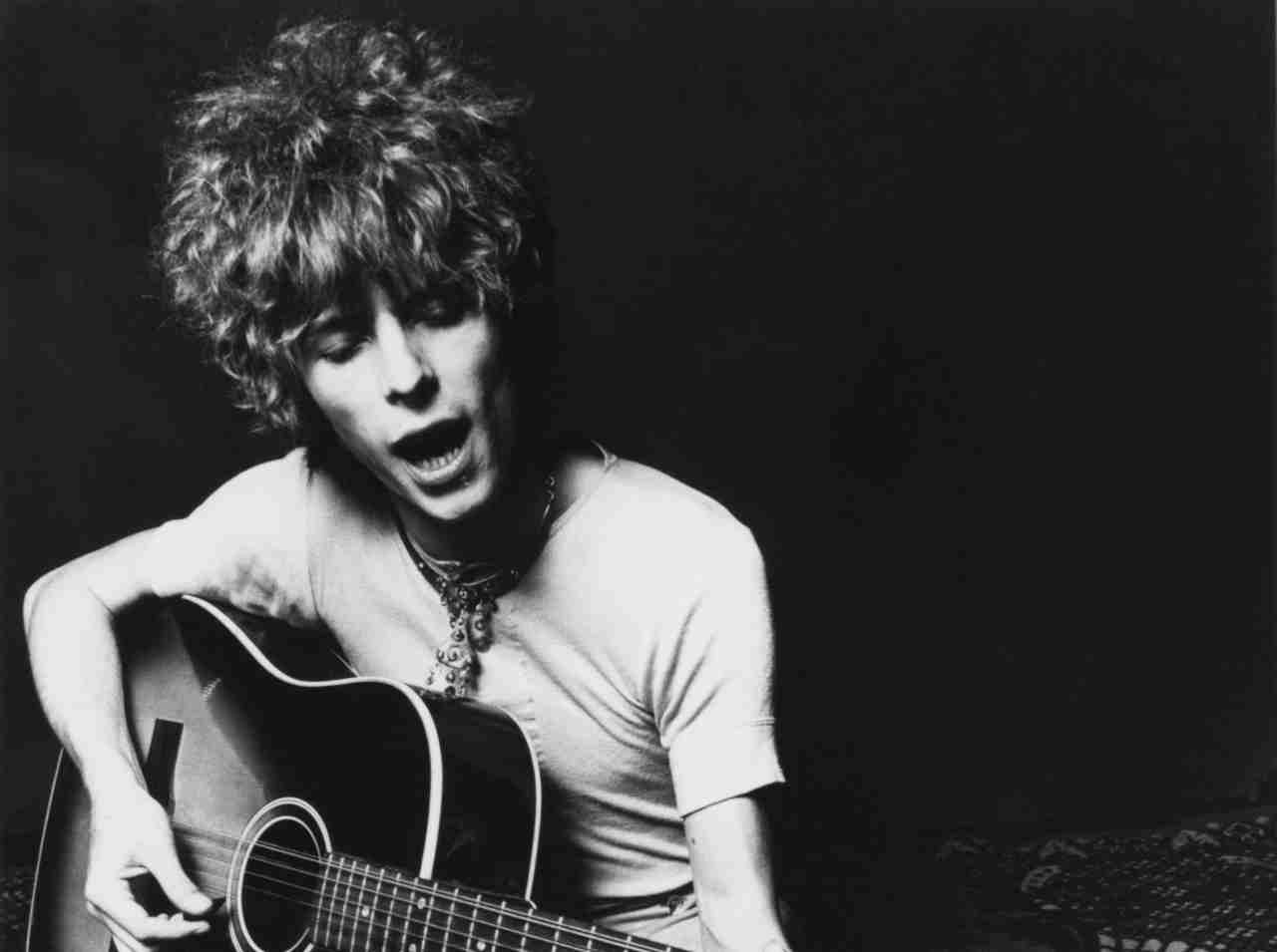 David Bowie playing an acoustic guitar in 1969
