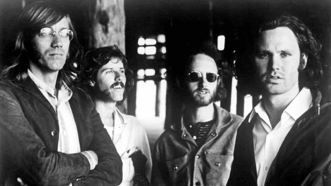 The Doors posing for a photograph under a pier in 1969