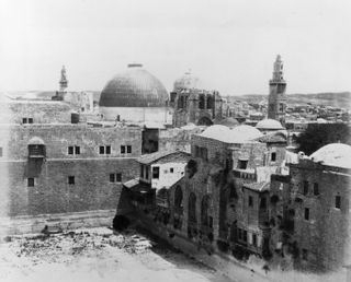 A photograph taken around 1900 shows the dome of the Church of the Holy Sepulchre in the Old City of Jerusalem. The Pool of Hezekiah, drained, is seen in the foreground.