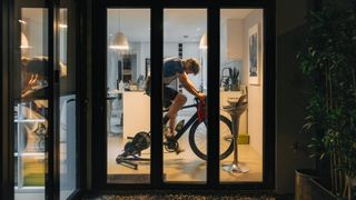 Man using an exercise bike at home late at night