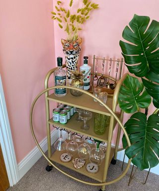 A diy bar cart drinks trolley painted with metallic gold spray paint and decorated with two hula hoops