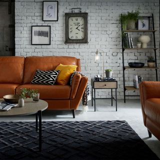 living room with white brick wall brown sofa with cushion and ladder shelf