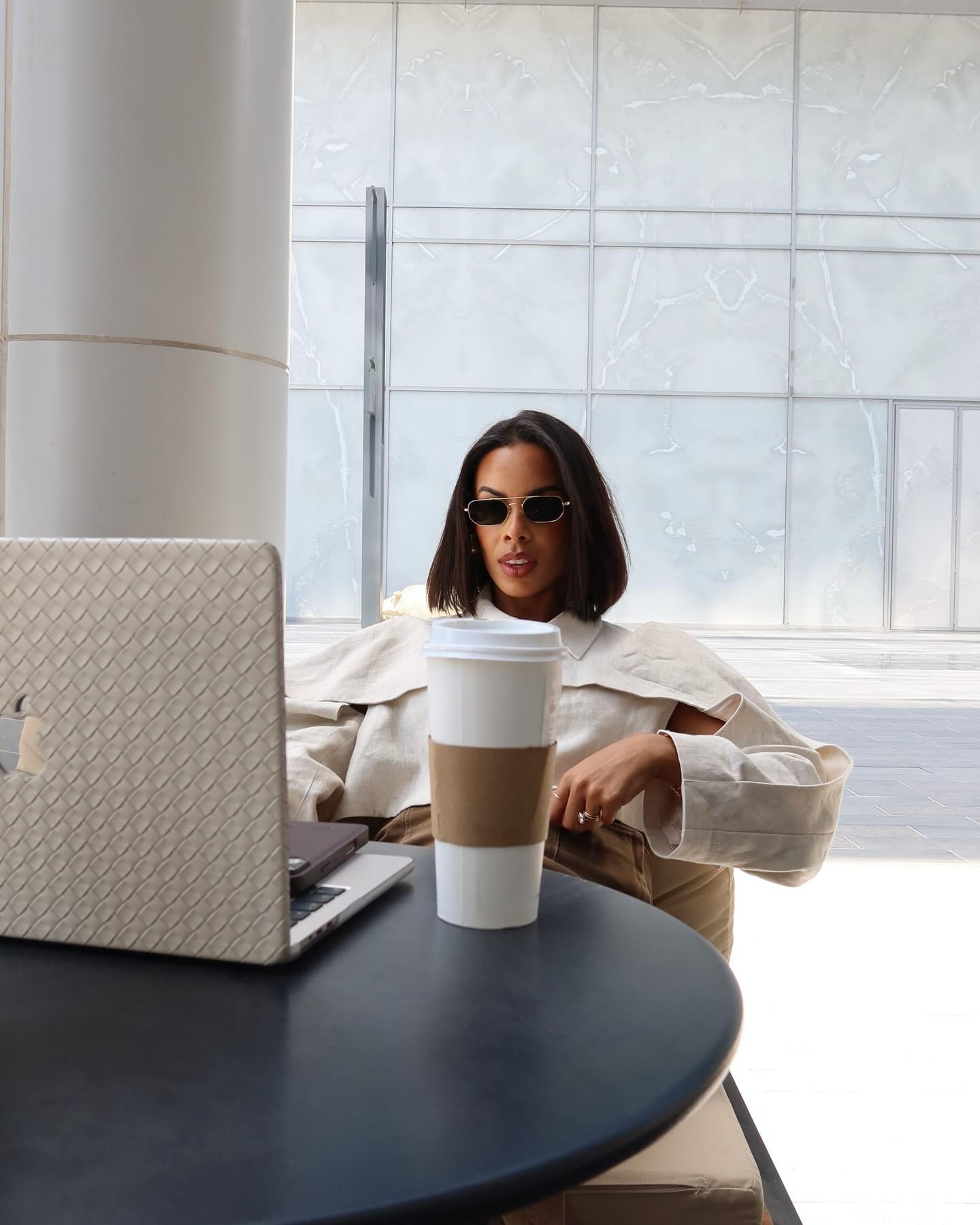 Rochelle Humes working on a laptop with a cup of coffee
