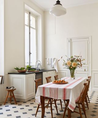 A Parisian apartment kitchen with chequerboard flooring and tall ceilings