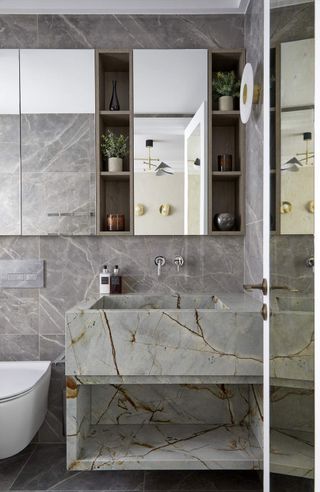 A bathroom with marble vanity and large mirrors