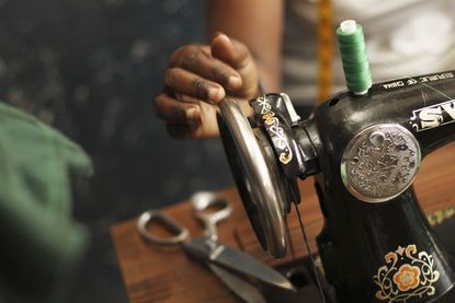 A woman uses a sewing machine.
