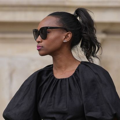 best mascaras for sensitive eyes - woman with high pony looking off to the left wearing sunglasses - gettyimages 1764002745