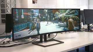 The Philips 498P9Z on a desk, displaying gameplay from Cyberpunk 2077.