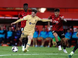 Gavi (L) vies with Mallorca's Spanish midfielder Antonio Sanchez during the Spanish League football match between RCD Mallorca and FC Barcelona at the Visit Mallorca stadium in Palma de Mallorca on October 1, 2022.