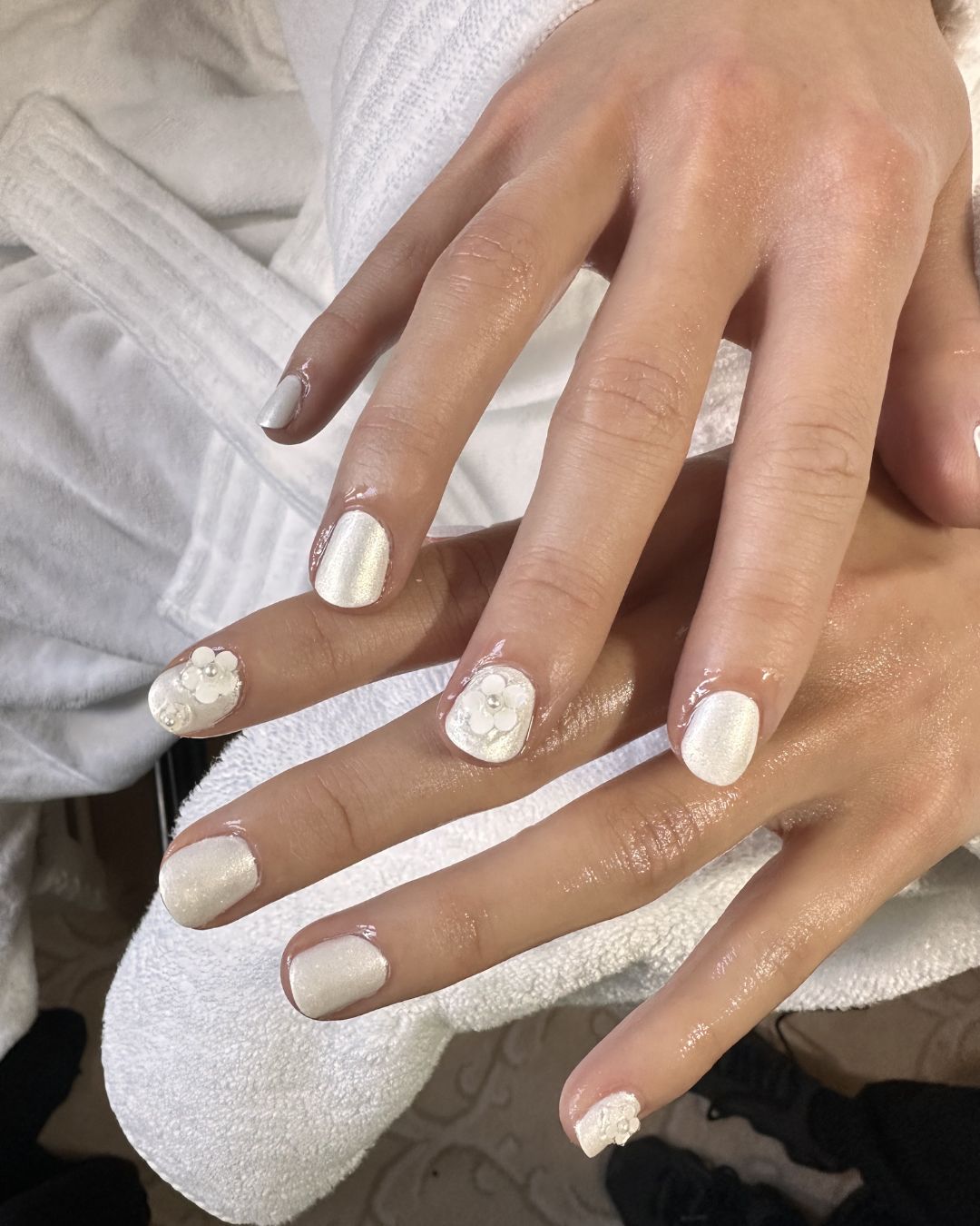 An image of singer Laufey's white, shimmery nails with 3D floral accents by Yoko Sakakura.