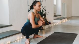 woman practicing yoga in garland position