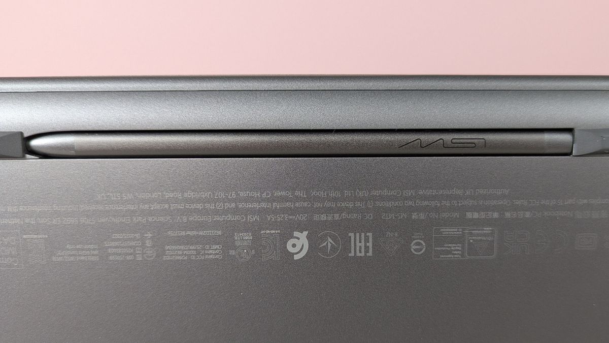 Close-up of MSI Nano Pen in compartment underneath MSI Prestige 14 Flip AI+, with pink wall in background