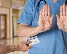 Doctor in scrubs in hospital refusing to treat a patient with a Medicare card.