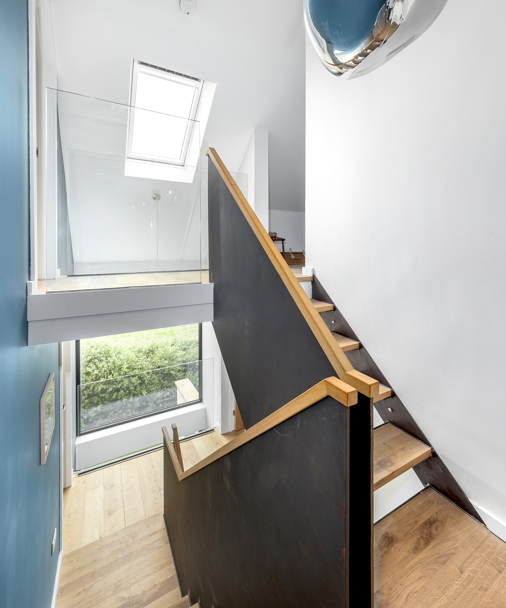 A staircase in a self build home leading up to a loft bedroom and donwsairs to the main entrance