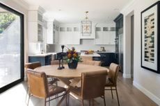 kitchen diner with round table and mix of white and dark cabinets behind