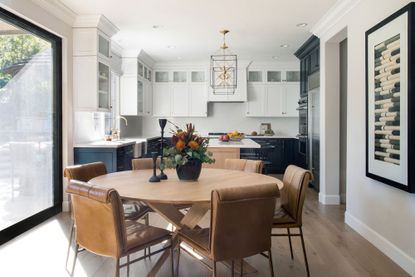 kitchen diner with round table and mix of white and dark cabinets behind