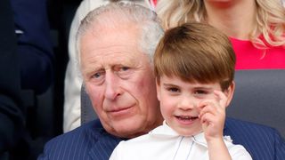 Prince Louis sits on his grandfather King Charles' lap