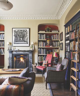 living room with paneling and in built curved book shelves and seats round fire