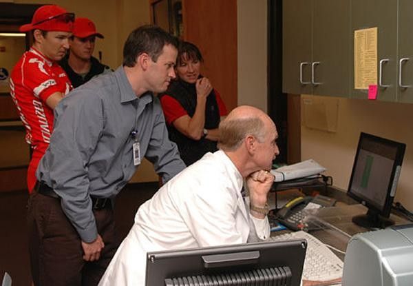 The entire crew gathers around the computer monitor