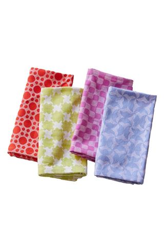 four brightly colored and patterned napkins folded in a line