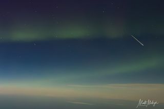 孤獨的隕石是一幅吹過天空的圖片,在飛機上射出的場景中扭曲的極光燈的花環。世界的曲線可以在下面看到。
