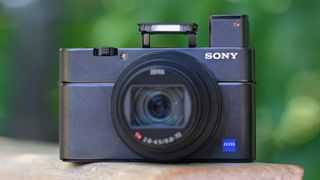 The Sony RX100 VII, one of the best travel cameras, sitting on a wooden bench
