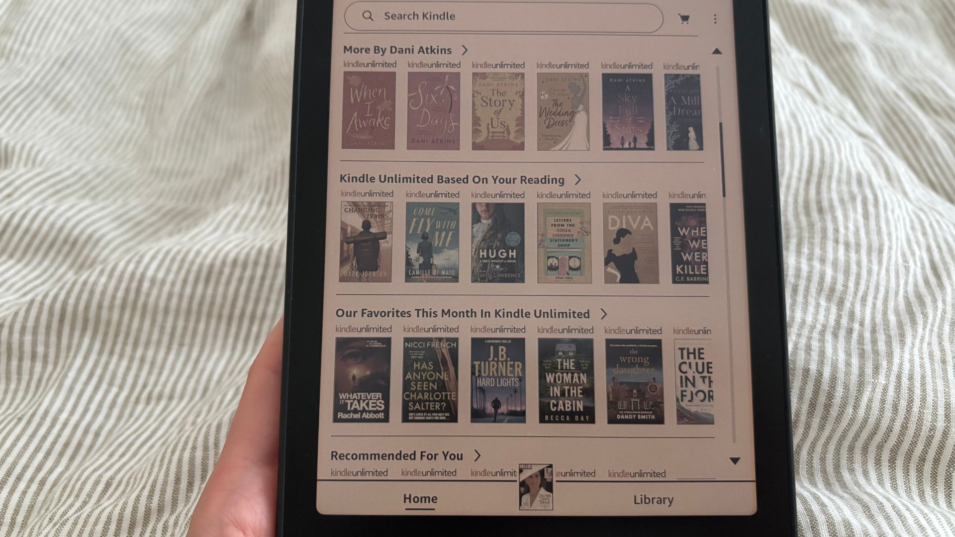 The Kindle Colorsoft with Kindle Unlimited open on my bed