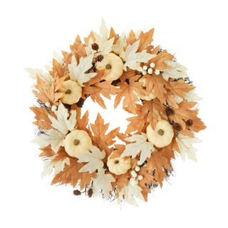 A fall wreath with pale orange and beige pumpkins and leaves on it