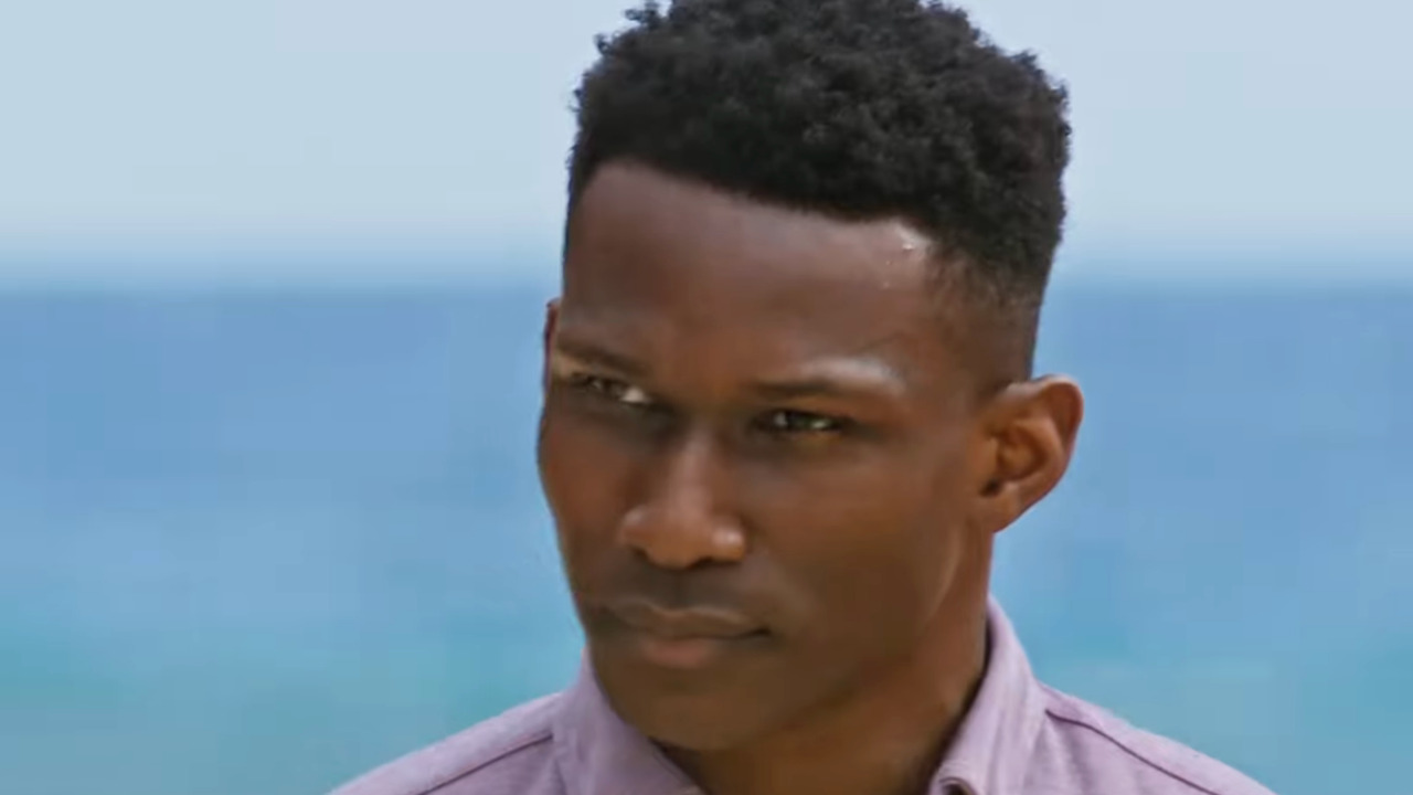 Q looks on intensely on the beach as Survivor 50 begins.