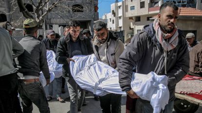 Palestinians carry body from Gaza City food convoy stampede