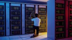 Male tech developer pictured working at a mainframe computer rack. 