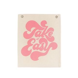 A tapestry that says 'take it easy' in retro writing