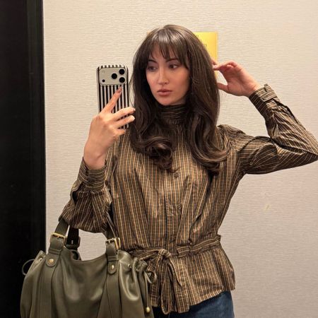 An image of Who What Wear associate beauty editor Alyssa Brascia taking a mirror selfie.
