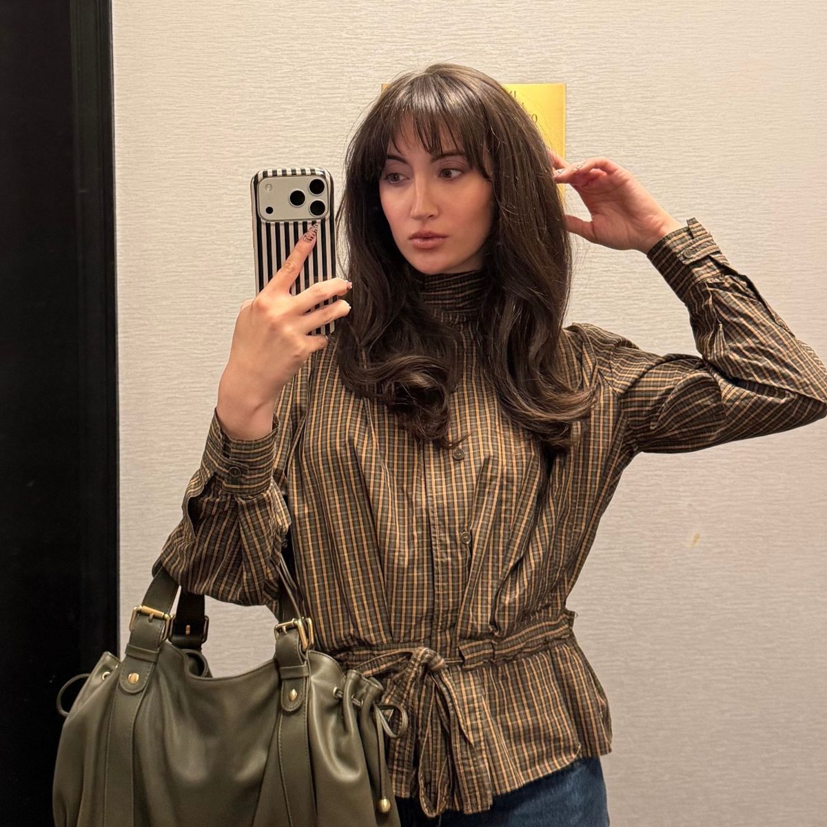 An image of Who What Wear associate beauty editor Alyssa Brascia taking a mirror selfie.