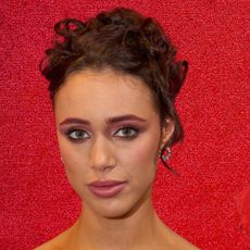 A woman wearing red-toned makeup next to three red blushes. All are in front of a red background. 