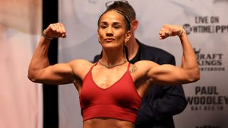 Amanda Serrano flexes her biceps during a weigh in ahead of the Amanda Serrano vs Heather Hardy fight.