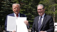 US president Donald Trump (left) holding a UK-US trade deal with prime minister Keir Starmer while speaking to the media at the G7 Leaders' Summit on 16 June 2025 in Kananaskis, Canada.