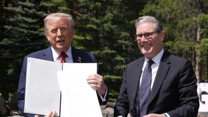US president Donald Trump (left) holding a UK-US trade deal with prime minister Keir Starmer while speaking to the media at the G7 Leaders' Summit on 16 June 2025 in Kananaskis, Canada.