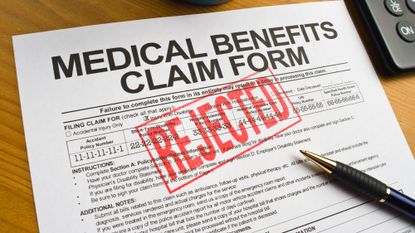 Medical benefits claim form sitting on a desk with a red "rejected" stamp