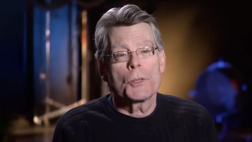Stephen King speaks to the camera, wearing a black shirt, in a behind-the-scenes segment for Under the Dome (2014). 