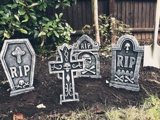 Halloween party ideas illustrated by pretend gravestones in soil