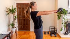 Woman performing kettlebell swing at home