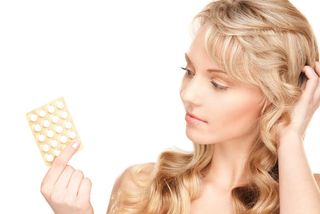 A woman holds a pack of birth control pills