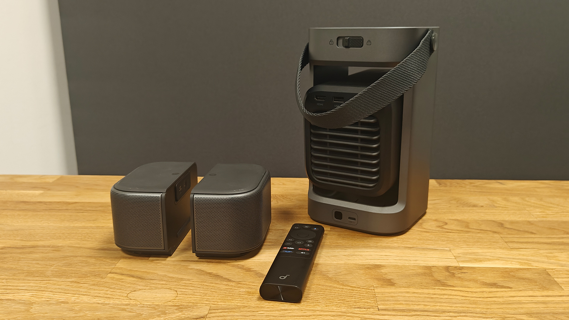 Soundcore Nebula P1 projector on wooden AV rack with remote control