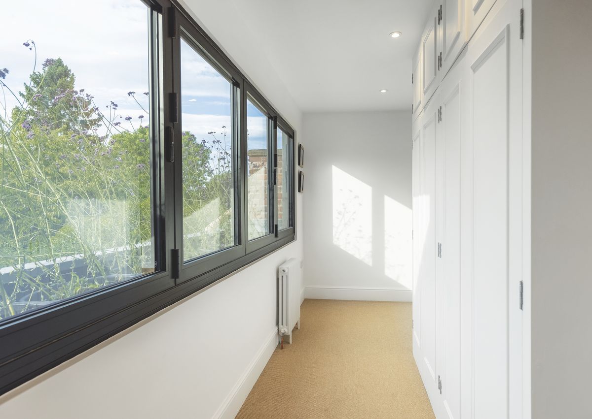 upstairs corridor in two storey extension with built in wardrobes and bifold windows