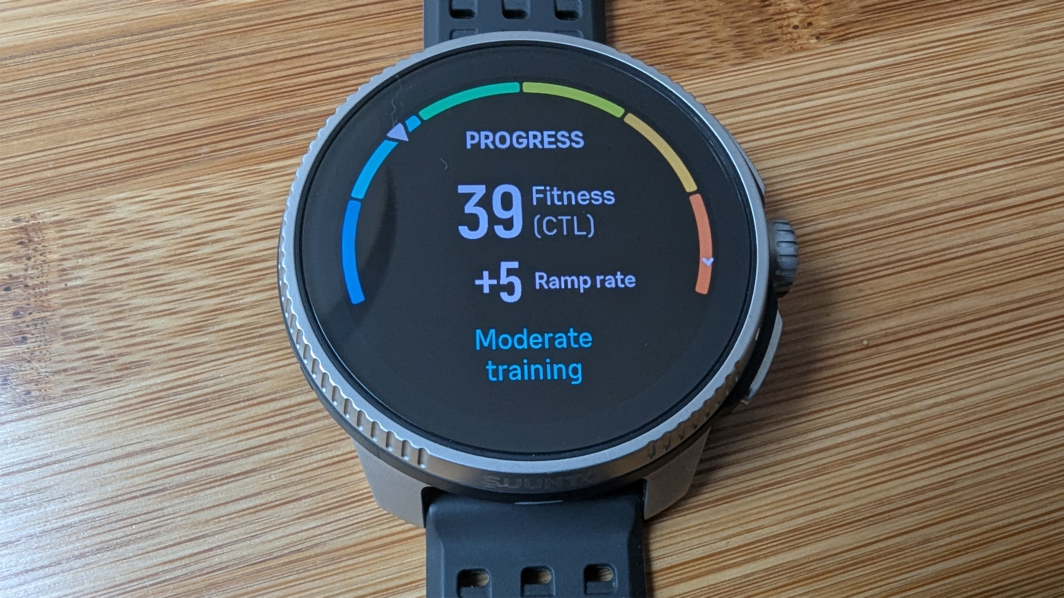 Suunto Race on a bamboo table showing an on screen progress tracker