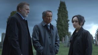 Alex Zahara and Tinpo Lee stand somberly with Kaitlyn Santa Juana in an overcast cemetery in Final Destination Bloodlines,