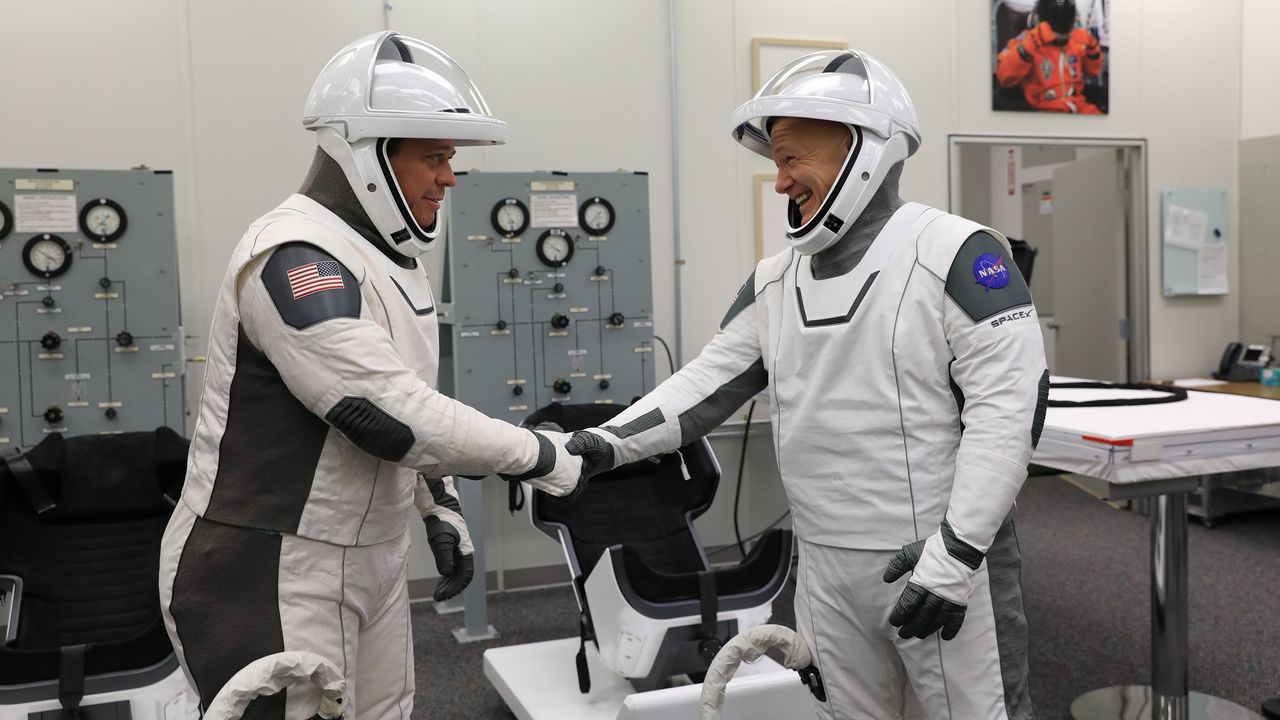 NASA astronauts Bob Behnken, left, and Doug Hurley shake hands after suiting up in SpaceX spacesuits in the Astronaut Crew Quarters at Kennedy Space Center in Florida on Jan. 17, 2020, during a dress rehearsal ahead of the company&rsquo;s uncrewed In-Flight Abort Test. A SpaceX Falcon 9 rocket and Crew Dragon spacecraft will lift off from Launch Complex 39A on the flight test, which will demonstrate the spacecraft&rsquo;s escape capabilities in preparation for crewed flights to the International Space Station as part of the agency&rsquo;s Commercial Crew Program. Behnken and Hurley are slated to fly on the company&rsquo;s first crewed mission, Demo-2.